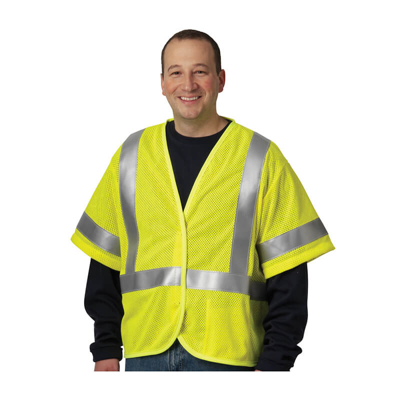 A smiling person wears a PIP ANSI Type R Class 3 AR/FR Mesh Vest 305-3100 over a dark long-sleeve shirt, standing against a white background.
