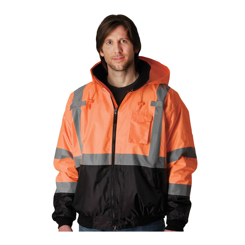 A person wears a PIP Waterproof Reflective Value Bomber Jacket 333-1766 in bright orange and black with silver stripes, hood, and front zipper. This high visibility jacket from PIP meets ANSI Type R Class 3 safety standards.