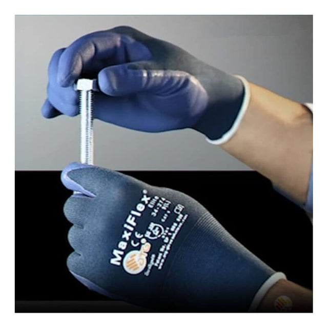 A person wearing blue PIP ATG MaxiFlex Elite Ultra Lightweight Work Glove 34-274 holds a metal bolt upright with one hand and steadies it with the other against a dark background.