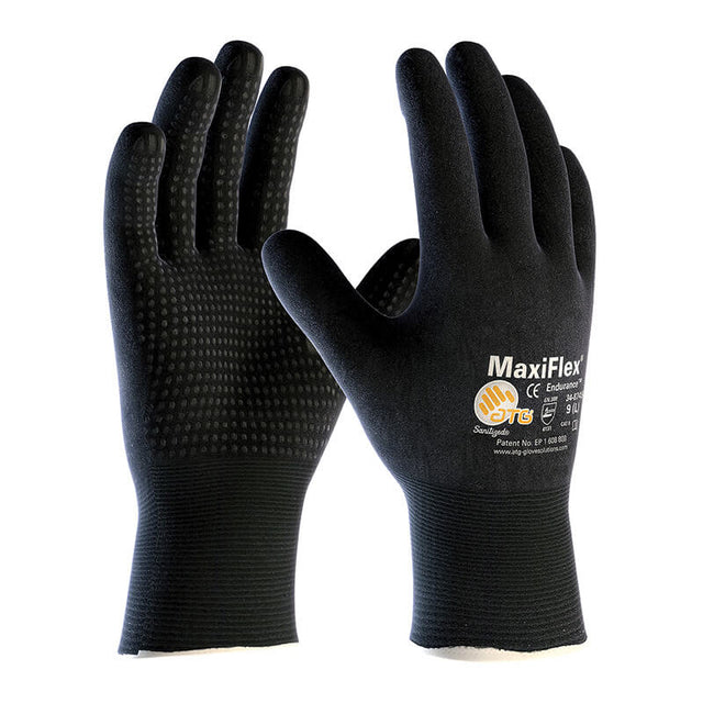 The ATG MaxiFlex Endurance Micro-Foam Nitrile Grip Glove 34-8745, available in a pack of 12 pairs from PIP - Protective Industrial Products, combines black and orange colors with a textured grip on the palms and fingers. Featuring white text and symbols, these gloves are Skin Safe Certified. They are crafted with Micro-Foam Nitrile to ensure both durability and comfort for extended wear.