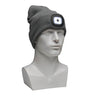 A white mannequin head is adorned with the gray PIP Winter Beanie Cap with LED light from Protective Industrial Products. The LED light is switched on, providing a bright glow ideal for cold weather protection. Designed with a slouchy fit, it comfortably covers the top of the mannequin's head.