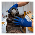 Wearing SHOWA 380 General Purpose Gloves by Showa Best, a person inserts a piston into the cylinder of a disassembled engine, surrounded by metal parts in a workshop setting.