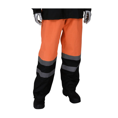 A mannequin dressed in PIP - Protective Industrial Products' PIP Viz Waterproof Pants with Black Bottoms 353-1202 stands against a white background. These high visibility orange and black pants feature reflective gray stripes and are paired with black boots. The loose-fitting design includes a durable ripstop shell, ensuring both safety and longevity.