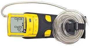 The BW Honeywell GasAlert Max XT II, encased in a BW GasAlert Max XT II Carrying Belt Case GA-HXT, is attached to a black holder. Next to it, a long coiled metallic tube from the gas detector accessories is secured by a strap. The digital display on the device shows numeric readings, likely indicating gas detection levels.