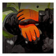 A person wearing PIP PowerGrab Thermal Insulated Hi-Vis Glove 41-1400 (12 pairs) in bright orange and a yellow safety jacket stands outdoors as snow falls, their clasped hands showcasing the glove’s textured grip and superior cold protection.