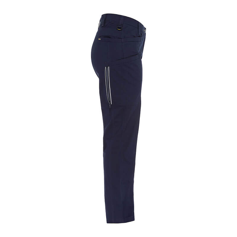 Side view of the PIP Bisley Women's Stretch Ripstop Vented Work Pants by NSA in dark navy blue, showcasing a zipper pocket on the side and belt loops at the waist. These pants are tailored with a straight fit and feature X-Airflow Ventilation for comfort along with UPF 50+ protection, set against a plain white background.