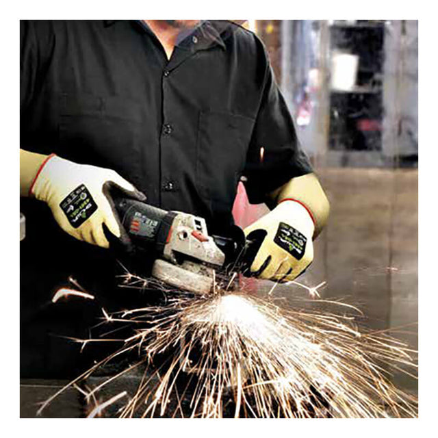 A person wearing SHOWA 4561 Cut Resistant Gloves by Showa Best operates an angle grinder, producing bright sparks. They are dressed in a black shirt against the backdrop of an industrial workspace.