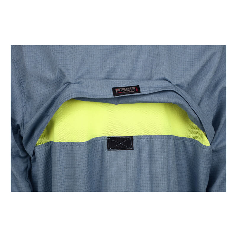 Close-up of the back of an MCR Summit Breeze 5.5 oz FR Shirt SBS100_ by MCR Safety, showing a flap that reveals a bright yellow mesh ventilation panel with triple vent technology and a sewn black label.