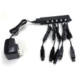 The RKI Instruments Multi-Unit AC Adapter for Charging 5 Instruments (49-0134) connects to a splitter box, delivering power through five cables—perfect for charging gas detectors—all items displayed on a white surface.
