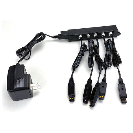 The RKI Instruments Multi-Unit AC Adapter for Charging 5 Instruments (49-0134) connects to a splitter box, delivering power through five cables—perfect for charging gas detectors—all items displayed on a white surface.
