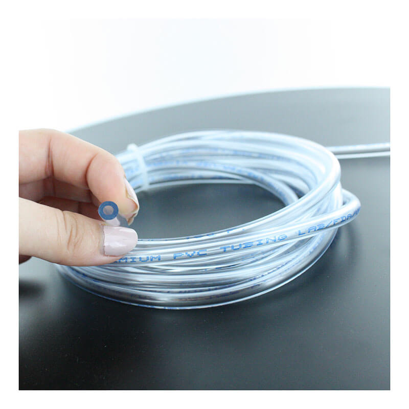 A hand holds the BW Technologies by Honeywell Tygon Calibration Hose 1 ft (C2-HOSE1-1), a transparent Gas Detector Accessory with blue writing, on a black surface—ideal for devices like the GasAlertMicroClip X3.