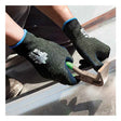 A person wearing SHOWA S-TEX 581 Cut Resistant Gloves by Showa Best, featuring a black design with a nitrile palm finish, uses a green-handled hammer on a surface, creating dust. Only the hands and part of the arms are visible.