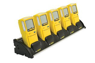 Five yellow GasAlert Max XT detectors are neatly arranged in a BW Honeywell BW Multi-Unit (5) Cradle Charger XT-C01-MC5. Each detector features a screen and buttons, precisely aligned against a white background, reflecting an image of precision and order.