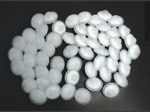 A spiral arrangement of multiple 25 mm white PTFE discs from the RAE Systems Water Trap External Filter set, featuring rounded edges against a dark background.