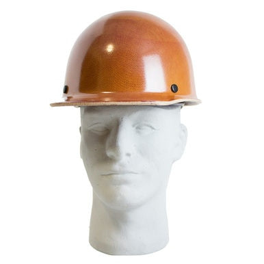 A natural tan MSA Skullgard Hard Cap (Model 475395) with Fas-Trac suspension for enhanced comfort is showcased on a white mannequin head. From the front, it features a glossy finish and a straightforward design with two black rivets on the sides, designed to endure radiant heat loads.