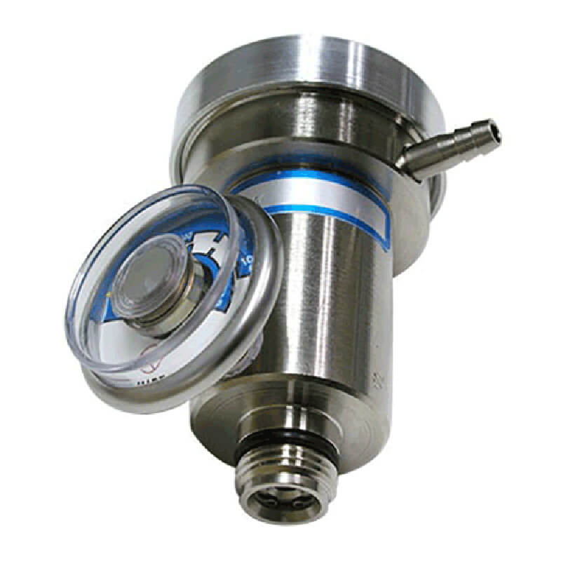 The RKI Calibration Gas Demand Flow Regulator by RKI Instruments includes a stainless steel pressure relief valve and circular gauge on top, utilizing demand flow regulator technology. This device features cylindrical components and fittings designed to regulate pressure in industrial settings, with a clear cap partially covering the gauge for precision control.