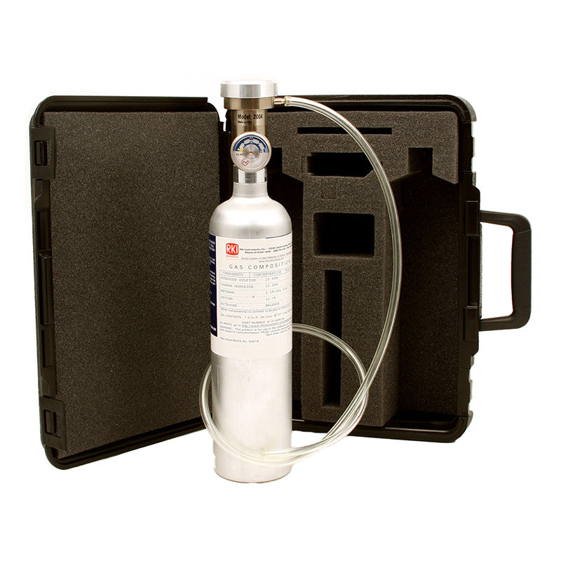 Displayed in front of an open black carrying case with custom foam padding, tailor-made for the RKI GX-2012 Calibration Kit by PK Safety Supply, is a silver gas cylinder featuring a pressure gauge and attached tubing. The case includes a handle on the right side to facilitate easy transport.