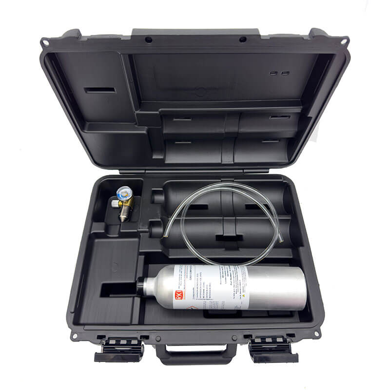 The RKI Instruments GX-3R/GX-3R Pro Calibration Kit includes a black hard-shell case with the RKI Instruments label. Inside, you'll find a metal cylinder, tubing, and a pressure gauge tool. These components are neatly arranged in custom compartments and secured with latches to ensure the safe transport of sensitive equipment.