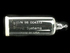 A small glass ampoule with the label "RAE Systems 9.8eV Replacement Lamp 050-0020-000" and serial number "S/N 98 004373," made in the USA, is visible against a black background. The ampoule is likely used for gas detection purposes.