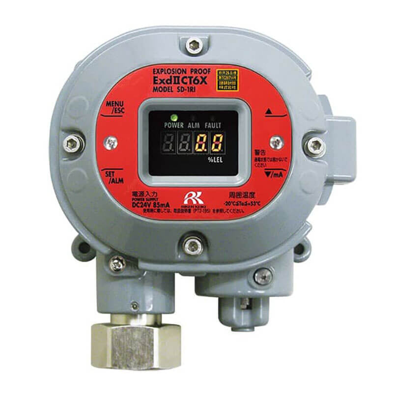 RKI Instruments' SD-1DRI-AS IPS LEL Detector with a 4-20mA Transmitter, designed for air aspirator applications, features an explosion-proof gray casing and a distinct red panel labeled "ExdII CT6X MODEL SP-1H." It includes an advanced infrared detector and has a digital display for numeric readings. The device is equipped with buttons to navigate menus and adjust settings, featuring text in both English and Japanese.