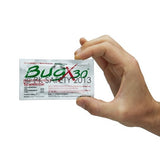 A hand holding a small packet of Coretex BugX Insect Repellent Towelettes from the 100/Case 12640 collection, featuring its water-based formula and labeled for outdoor use.