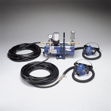 An Allegro 2 Worker Half Mask Airline Respirator System sits on a gray surface, featuring black hoses and gauges. This low-pressure respiratory protection system includes two connected half masks, each supplied with its own hose, providing comprehensive air respirator functionality.