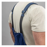 A person in a beige t-shirt wears NSA's Enespro ArcGuard Performance 40 Cal Arc Flash Bib ARC40B, featuring dark adjustable shoulder straps, shown from the back against a plain gray background—designed for arc flash protection.
