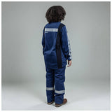 A person with curly hair, seen from behind, is wearing an NSA Enespro ArcGuard Performance 40 Cal Arc Flash Jacket ARC40J with reflective stripes and brown shoes, standing against a plain gray background.