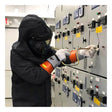 Wearing a PIP NOVAX Class 0 Electrical Safety Kit 147-SK-0, a worker operates a switch on an industrial electrical control panel.