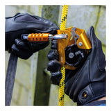Wearing black gloves, a person attaches a yellow and black rope to a gold Petzl ASAP Compact Mobile Fall Arrester for Rope B070AB00 with a locking carabiner, ensuring rope safety for climbing or harness systems.