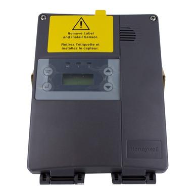 The Honeywell E3Point Network Single Gas Monitor 1309A004_ from Honeywell Analytics, integrated within a Building Automation System, comes with a protective yellow label on top that provides installation instructions for the sensor. The front features a small digital display and buttons, encased in a dark gray housing.