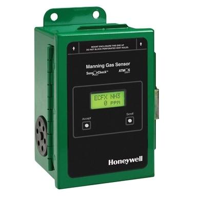 The image features a green Manning EC-FX Ammonia Gas Sensor by Honeywell Analytics. On the front panel, the display reads "ECFX NH3" with "0 PPM," and includes menu options for "Accept" and "Scroll." This rectangular ammonia detection system, model ECFX-100, comes with a convenient mounting bracket on top.