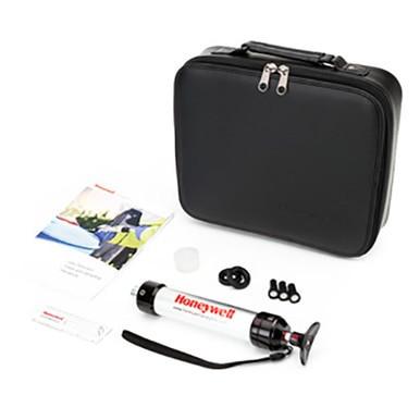 A BW Honeywell LP-1200 Piston Hand Pump calibration kit, which includes a black zippered carrying case, a white manual pump with a strap, multiple black attachments for gas detection tubes, and an instruction booklet.