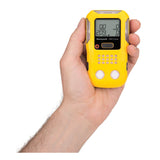 A hand holds a BW Technologies by Honeywell BW Clip4 4-Gas Detector (BWC4-Y-N) in yellow, featuring a digital display and front control buttons.