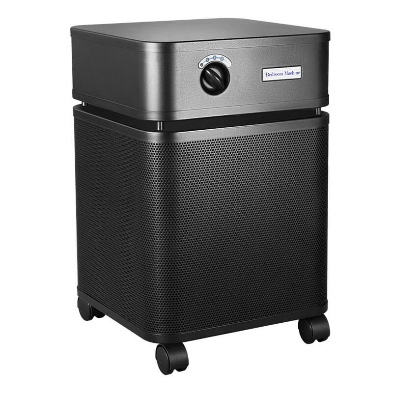 The Austin Air Systems Austin Air Bedroom Machine B402 is a black, box-shaped air purifier with a front control knob, ventilation holes, four wheels for mobility, and a medical grade HEPA filter for superior air quality.