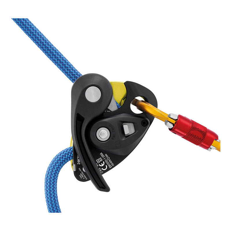 A black Petzl GRIGRI + Belay Device (D015AA0_) is attached to a blue climbing rope with a yellow carabiner that has a red locking mechanism.