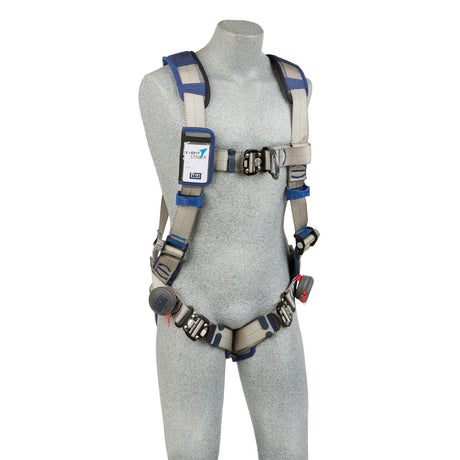 A mannequin wearing the 3M DBI-SALA ExoFit STRATA Comfort Vest Climbing Harness in gray with blue accents. This harness from 3M DBI-SALA Fall Protection includes adjustable straps, buckles, and padding for enhanced comfort and security. A label is visible on the chest strap.