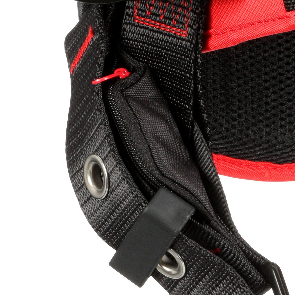 Close-up of a black and red backpack strap, reminiscent of the 3M Protecta Vest-Style Positioning Harness from 3M DBI-SALA Fall Protection, featuring a zippered pocket with a red zipper pull. The durable fabric evokes fall protection, complete with metal eyelets and reinforced stitching for added security.