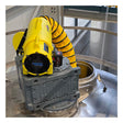 A Euramco RAMFAN UB20 18VDC industrial ventilator with a Quick-Couple Canister and flexible duct is connected to a gray metal opening on top of a large tank, delivering confined-space ventilation within the facility and enclosed by a metal safety railing.