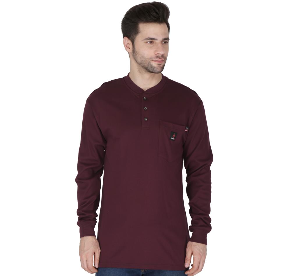 A man wearing the ForgeFR Henley MFRHNLY-004, featuring a chest pocket and long sleeves in maroon, stands against a plain white background. His short dark hair enhances his sideward gaze. This Henley is compliant with NFPA 2112 standards and boasts an impressive arc rating ATPV of 11 cal/cm² for extra safety.