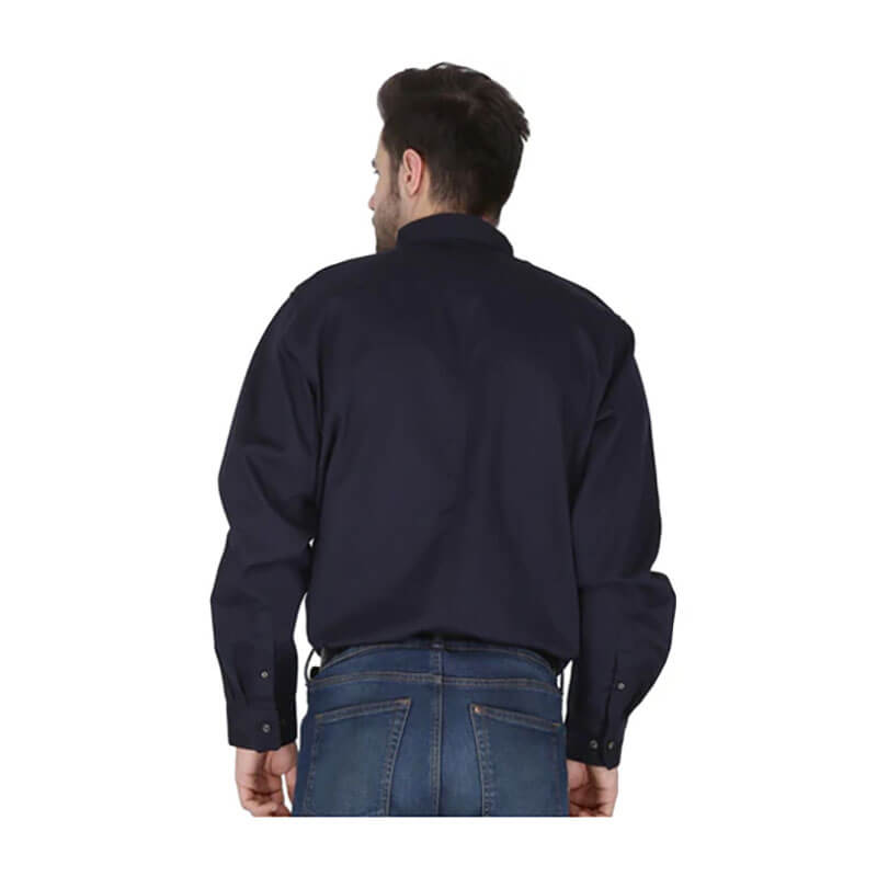 A man stands with his back to the camera, wearing a ForgeFR Forge FR Solid Button Shirt MFRLB2PS024 in dark navy and blue jeans against a plain white background.