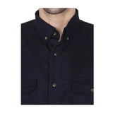 Close-up of a person wearing the ForgeFR Forge FR Solid Button Shirt MFRLB2PS024, a dark navy blue NFPA 2112 flame resistant shirt with a collar and two front pockets. Image shows only the lower face, neck, and upper torso.