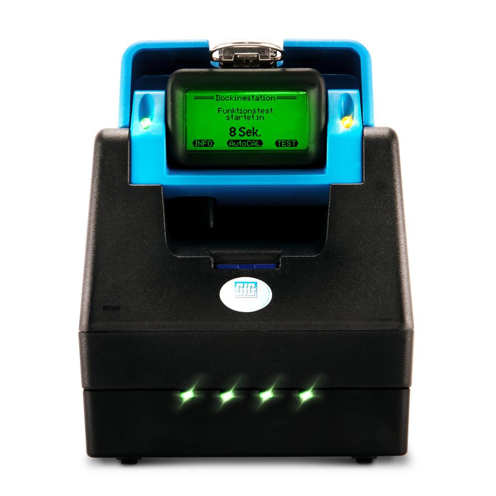 A GfG DS400 Docking Station for the G888/G999 Monitor, in black by GfG, includes a small screen displaying the message "Funktionstest starten in 8 Sek." This multi-gas detector features a blue top section and several green indicator lights, ensuring reliable automatic calibration for enhanced safety.