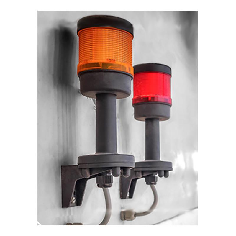 Two industrial warning lights from the GfG brand, compliant with the ATEX Directive 94/9/EC, are mounted on a wall. One light is orange and the other is red; both feature protective black casings and attached electrical wiring. A neutral gray background complements this robust setup featuring the GfG GMA200 Series Fixed Controller 200MT-.