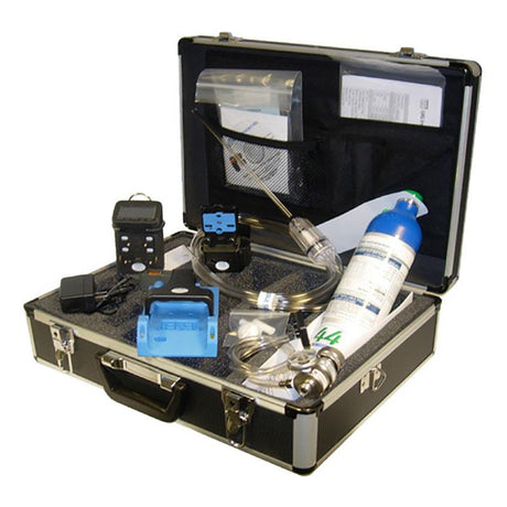 A black case contains the GfG Microtector II G450 4 Gas Detector (Rechargeable) G450-11420, accompanied by a blue digital device, cables, a small gas cylinder for automatic calibration, and a charger. The interior is equipped with foam padding and a mesh pocket for papers, ensuring everything is neatly organized inside.