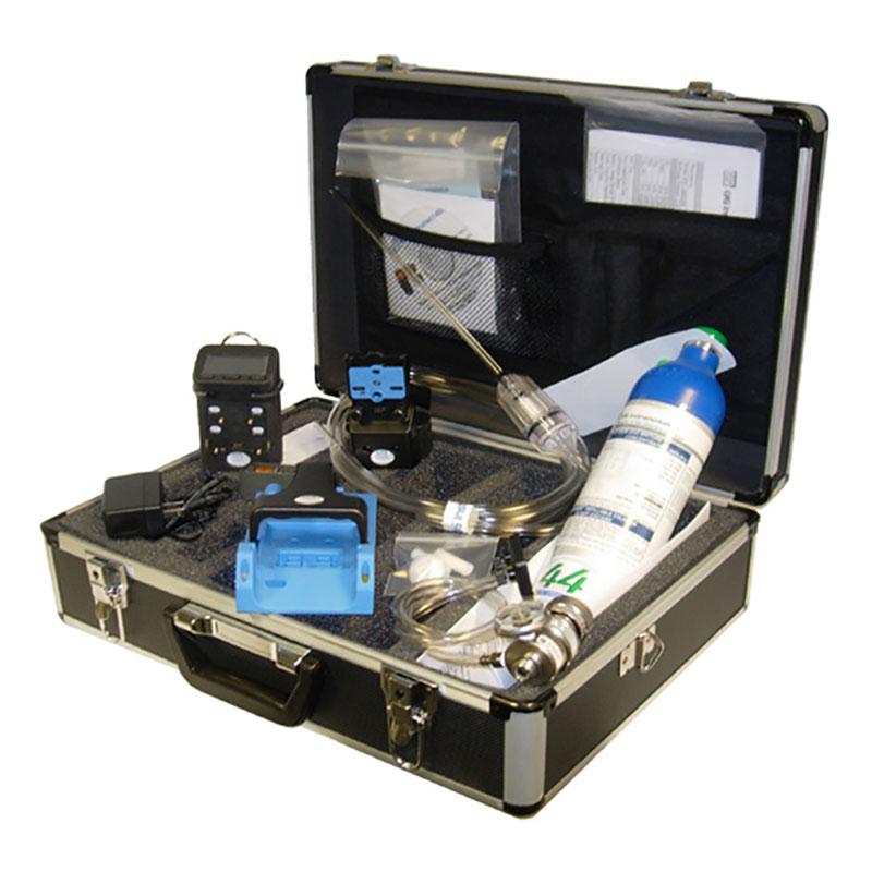 A black and silver case featuring a range of scientific or technical instruments, including a GfG Microtector II G450 4 Gas Detector (Rechargeable with Alk. Smart Pump) from the brand GfG, along with automatic calibration capabilities, cables, a black electronic device, and other tools—all neatly arranged inside.