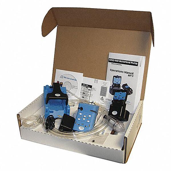 An open cardboard box containing a GfG Microtector II G460 Gas Detector with blue components, clear tubing, and an operations manual featuring Smart Sensor Design.