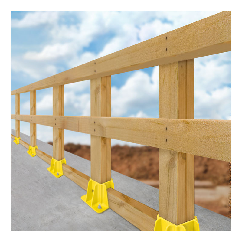 A Frontline Fall Protection Safety Guardrail with yellow GPB200 Boot Base supports is installed along a sloped concrete edge, set against a backdrop of blue sky and clouds.