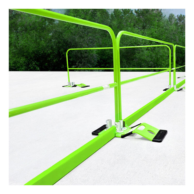 Vivid green Frontline Guardrails 56 lbs Base GUB56 by Frontline Fall Protection are set up on a flat white rooftop, surrounded by trees and greenery beneath a cloudy sky as part of a non-penetrating fall prevention system.