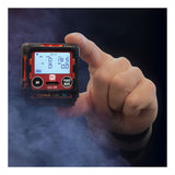A hand holds the RKI Instruments GX-3R 4 Gas Confined Space Monitor 72-RA-C with a lit display screen showing gas readings and buttons labeled AIR and POWER MODE, surrounded by mist—ideal for confined space monitoring.
